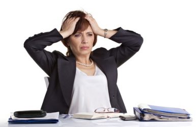 21326018 - senior businesswoman tear hair, sitting on a table with notebooks and glasses isolated on white